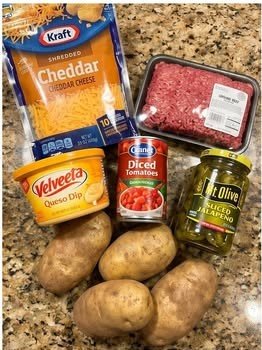 Ingredients for loaded queso burger potato cups including potatoes, ground beef, queso, tomatoes, jalapenos, and cheddar cheese