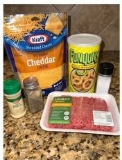 Ingredients for crispy cheeseburger onion ring cups including ground beef cheddar cheese onion rings and seasonings