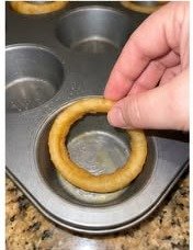 Large onion ring placed in a muffin tin cup as the base for cheeseburger onion ring cups